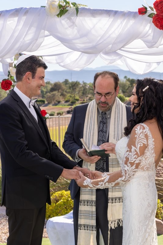 Rabbi Sandy officiating an outdoor wedding under a chuppah